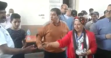 مواطنة ترتدى "علم مصر" وتوزع الحلوى أمام لجان الاستفتاء بالدقى